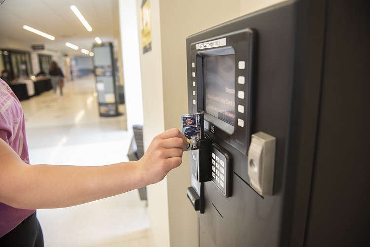 A student swipes card at a PHiL Station