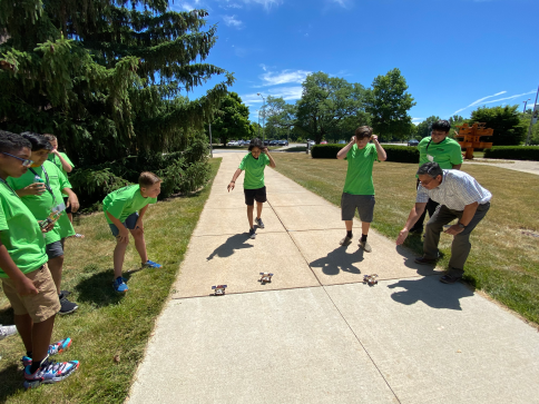 A group of students walk on a sidewalk.