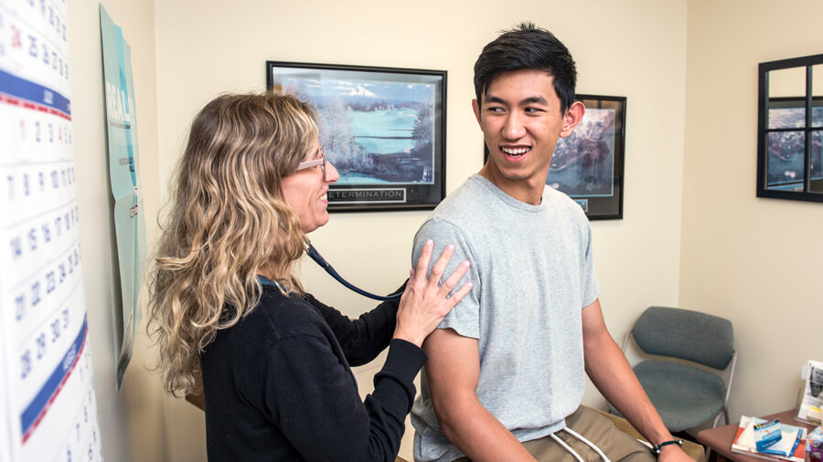 A Health Clinic provider tends to a patient.