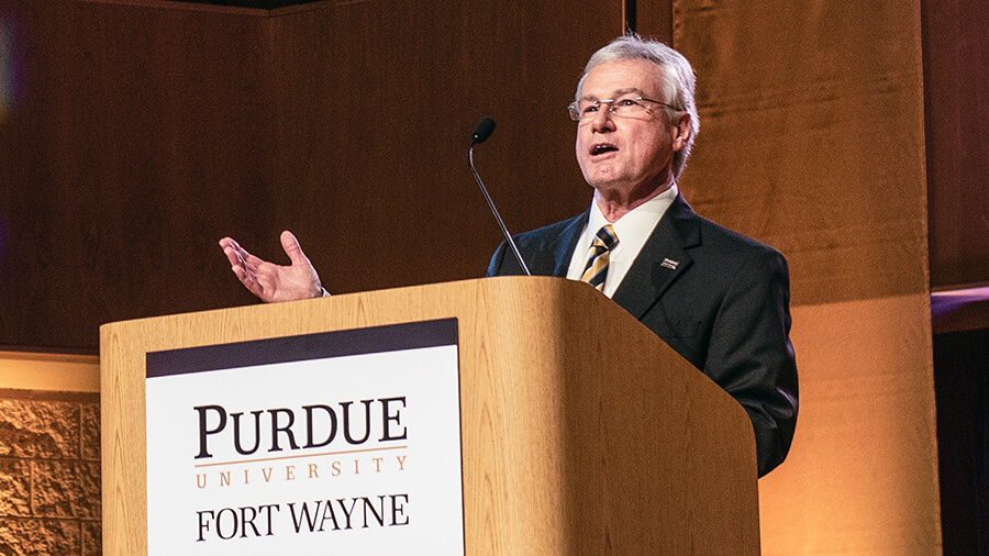 Chancellor Elsenbaumer Speaking at the Podum in Rhinehart Music Center