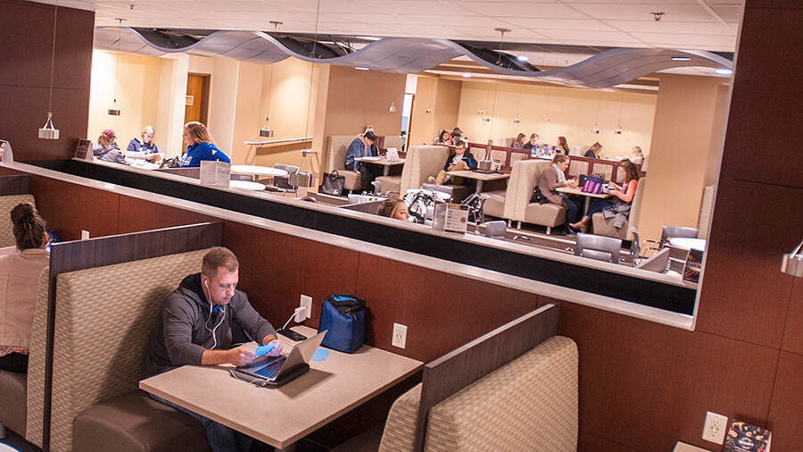 A wide view of students studying and eating in a dining hall.