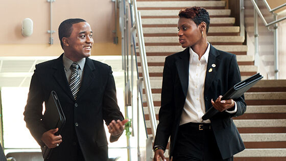Two business students walk together while discussing a class session.
