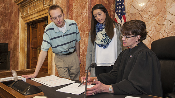Judge explaining a document to two purdue fort wayne students