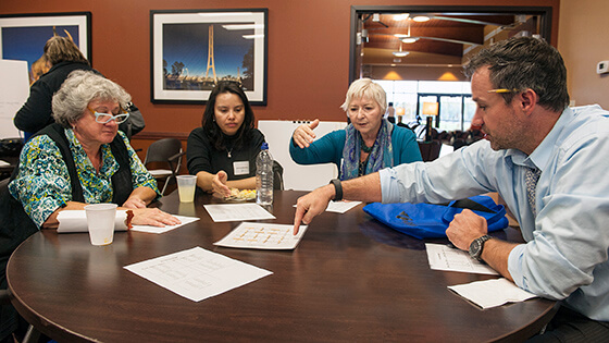 Four teachers at a round table have a discussion.