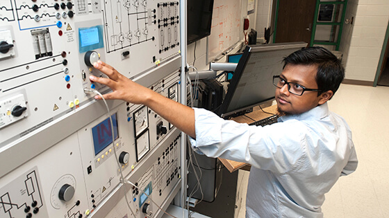 An engineering, technology, and computer science student using a machine.