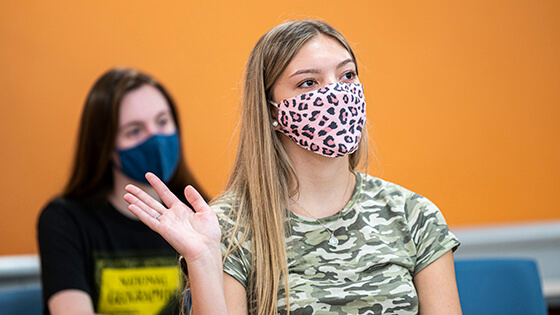 A Purdue Fort Wayne student raises their hand in class.