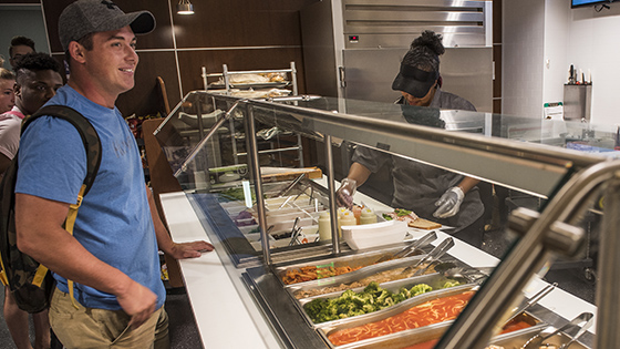 Student Waiting in Line to Receive a Hot Meal