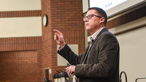 An employee stands up while giving a speech.