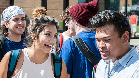 Students outside at an event talking