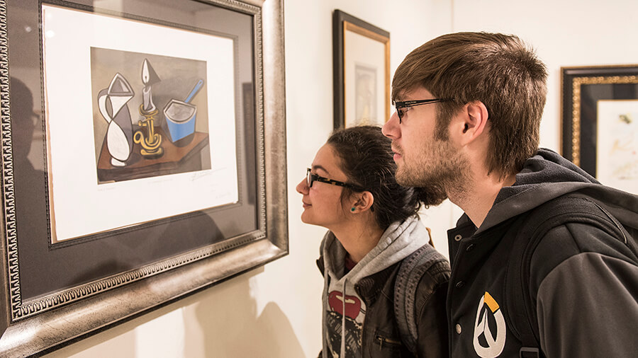 Students inspecting a hanging painting