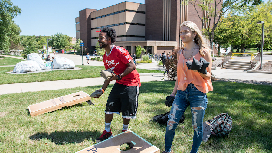 Two PFW students play a game of Cornhole.