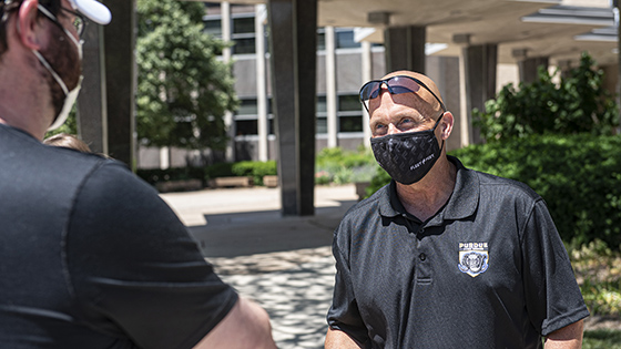 Purdue Fort Wayne Athletics staff members wear masks during a discussion outside.