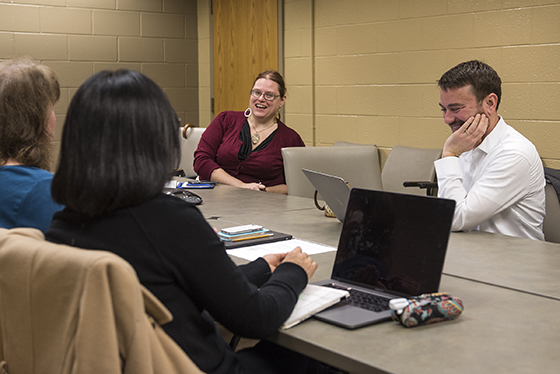 Two instructors laugh during a meeting.