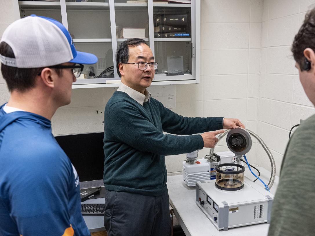 Professor using sample coating machine.