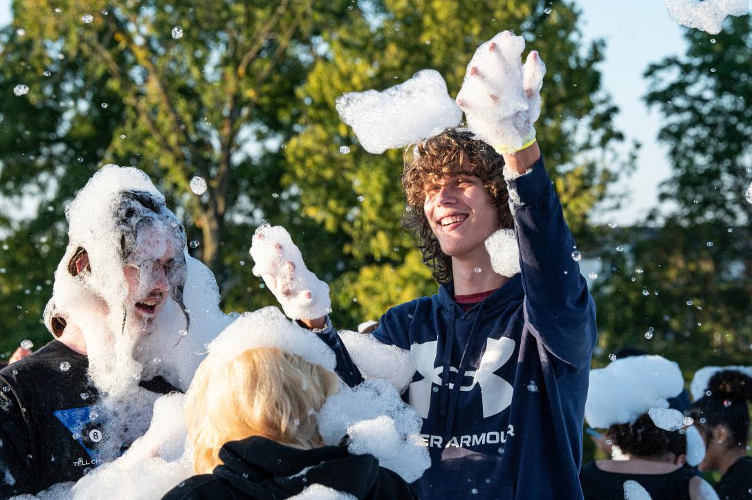 students playing with foam outdoors