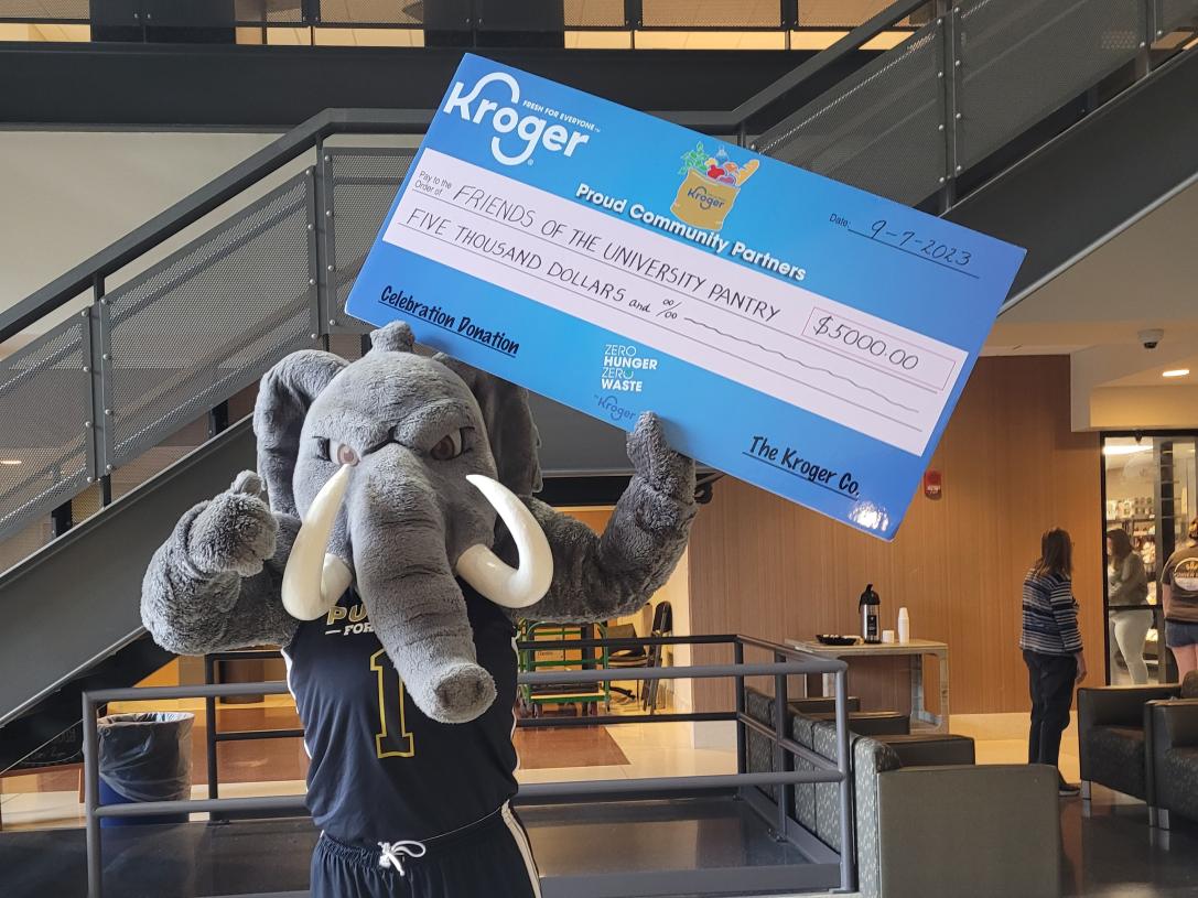 don mascot holding a large check