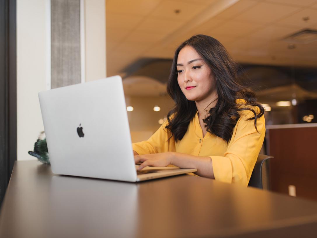 Female student working on her laptop indoors.