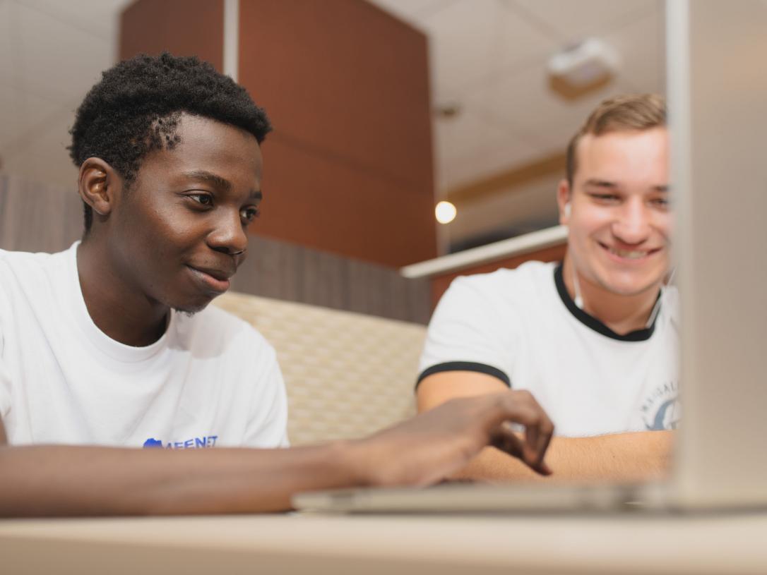 Male students studying class notes.