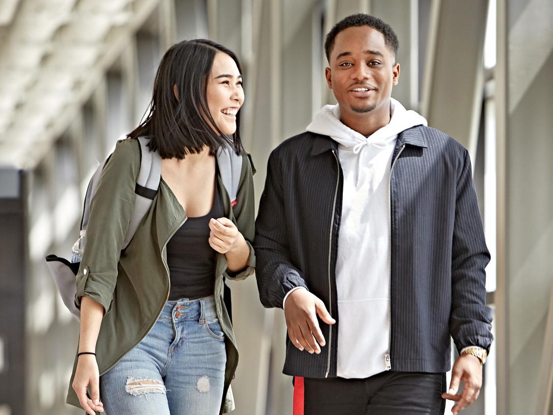 A couple walking in the student commons skybridge