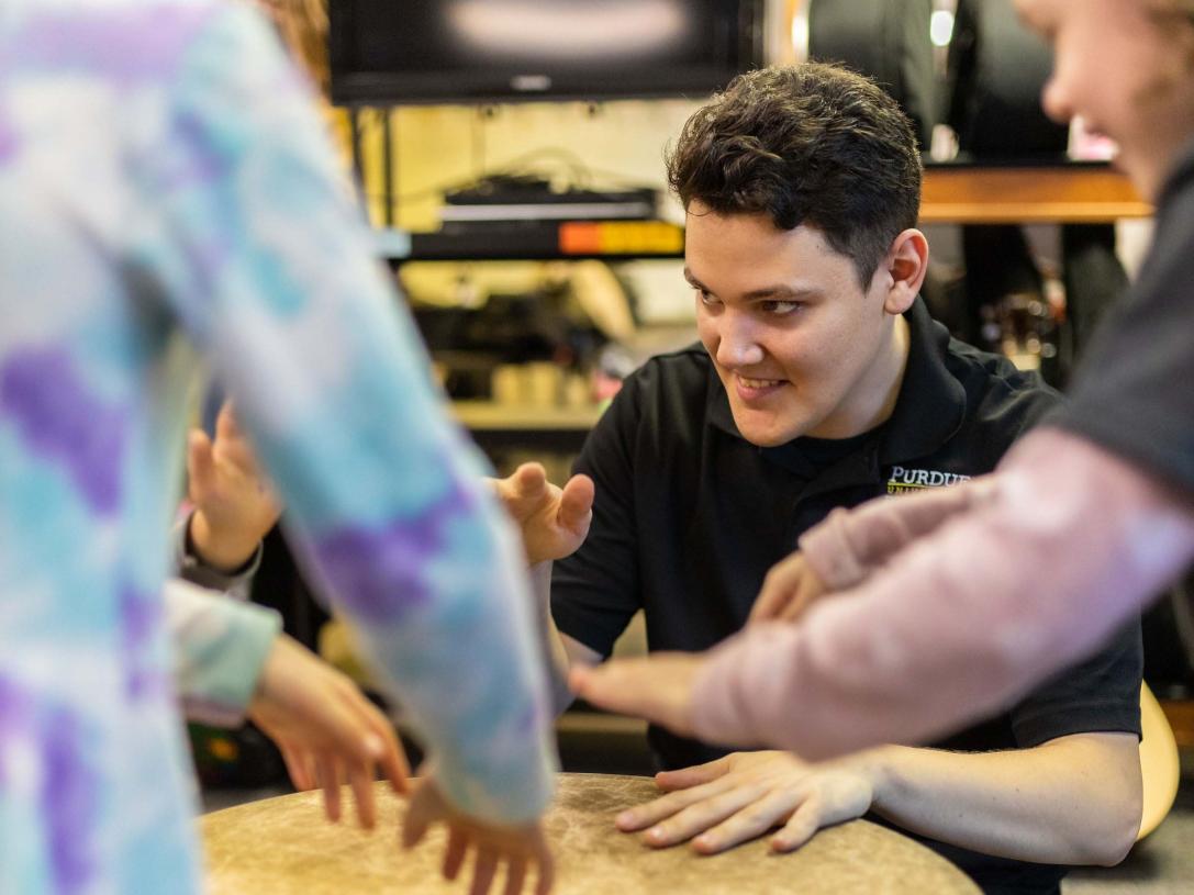 Trevor Perkins, a music therapy undergrad at Purdue Fort Wayne, leads improvisation with a gathering drum.