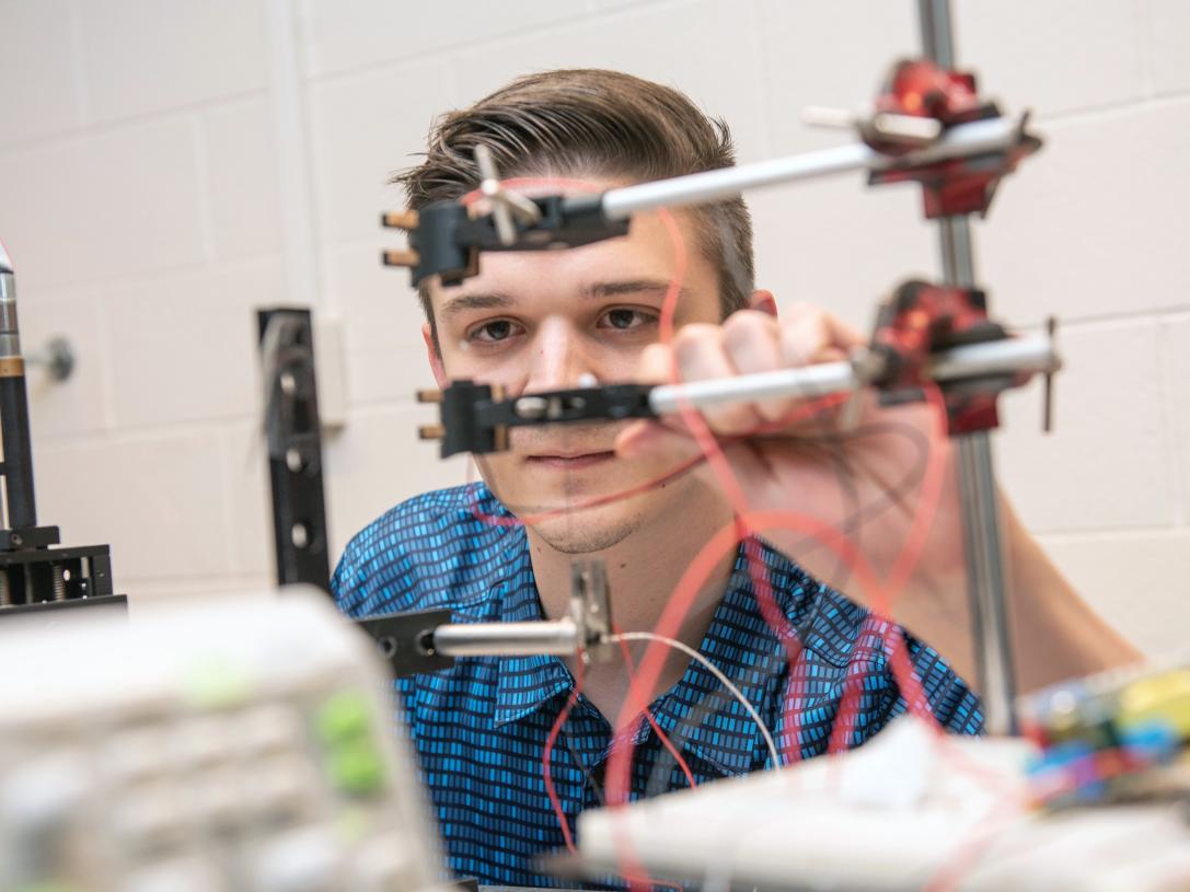 A physics student and his project in a lab