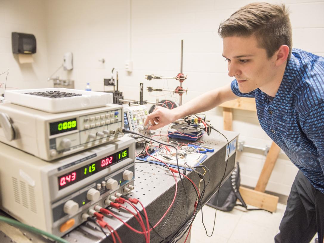 A physics student and his project in a lab