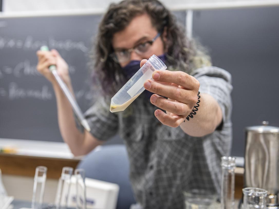 A Biology instructor examines a vial