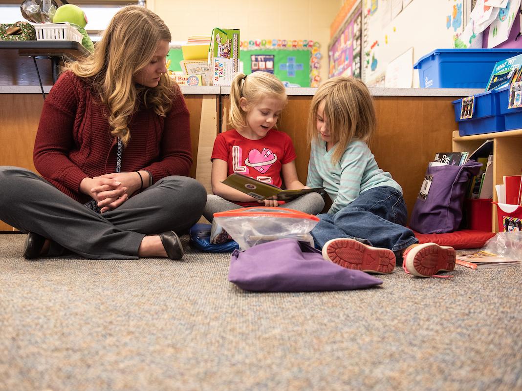 Teacher and young students reading