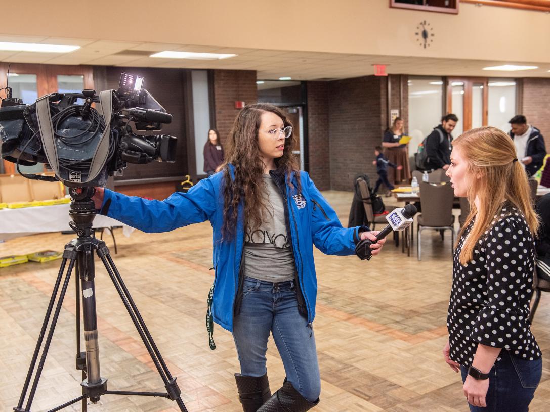 Student being interviewed by a news reporter.