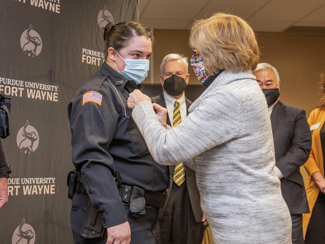 Officer Wojnarowski's mother pins a lifesaving award to her uniform