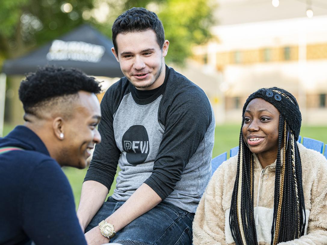Students sitting outside having a conversation.