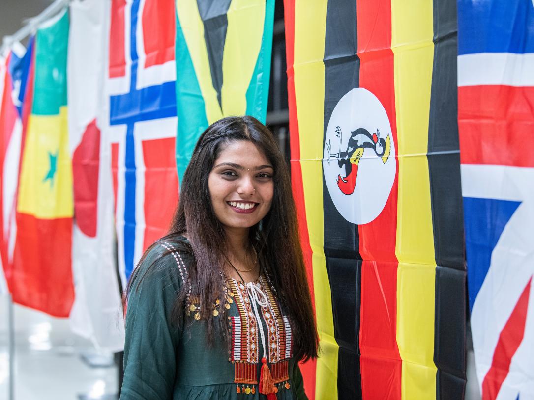 Student in front of flags