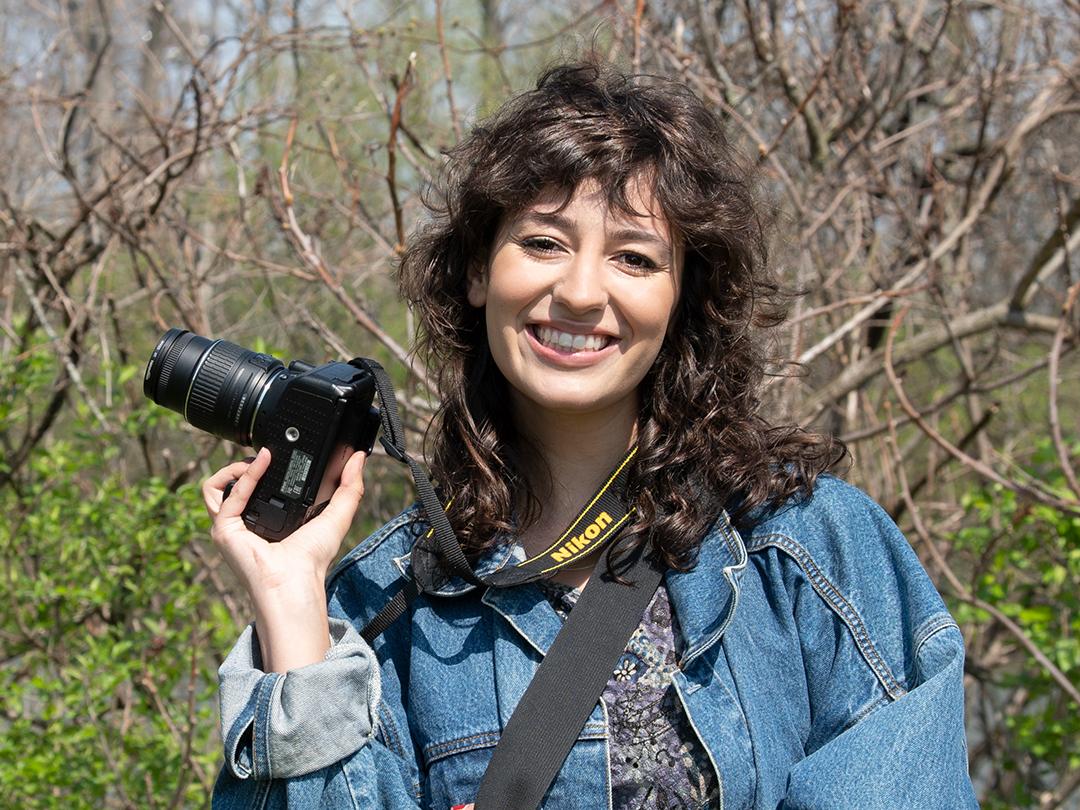 Portrait of Bella Ferrin holding her camera