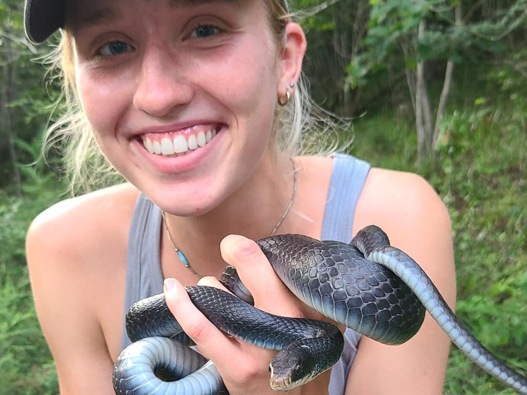 Katie Brandewie, student, holds a snake during an immersive learning experience.