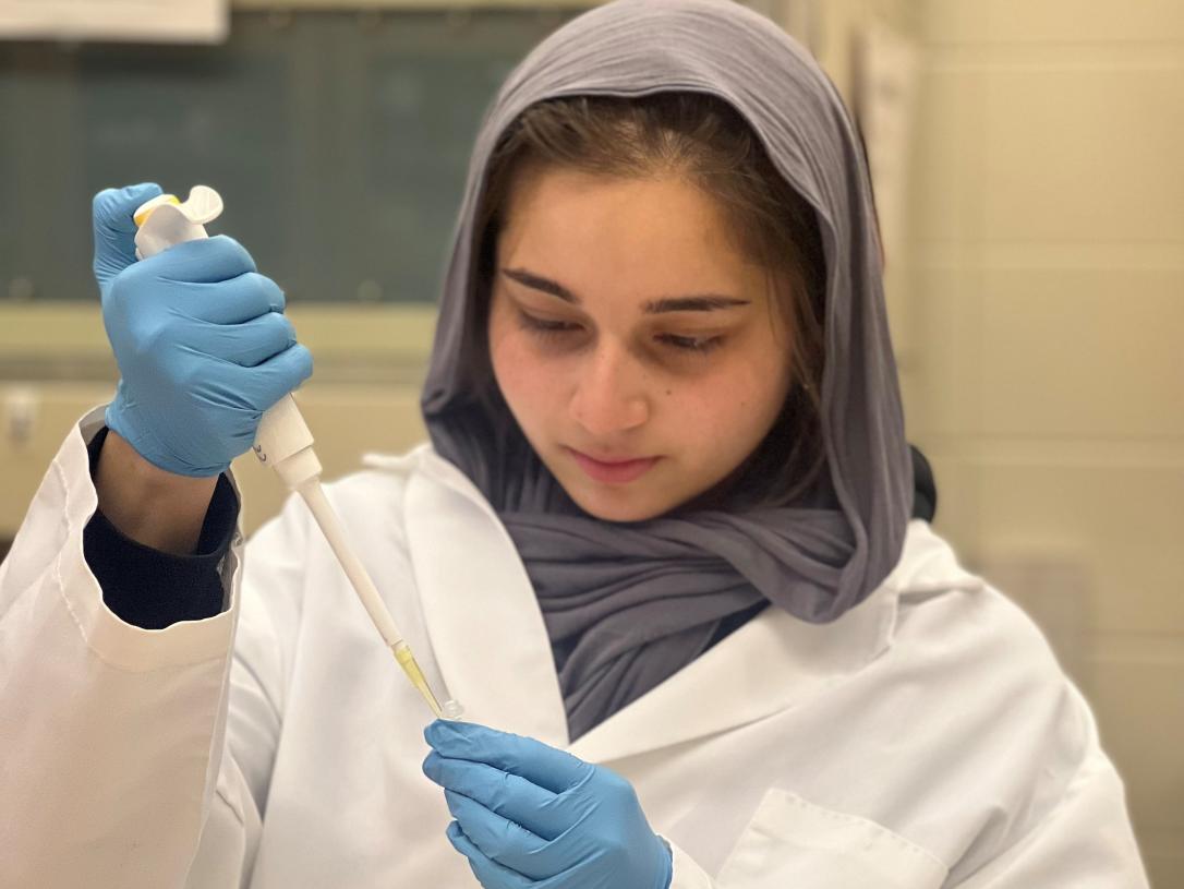 Malaria Ahmed, student, works in a lab.