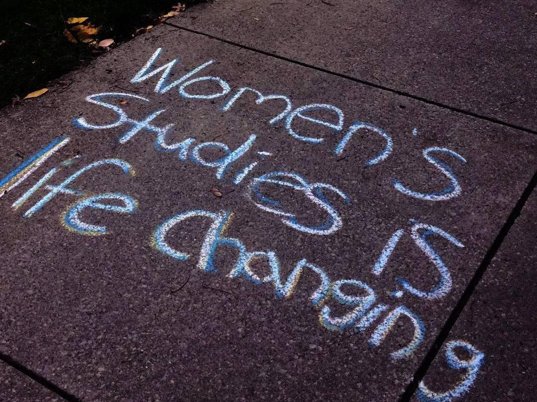 Chalk writing that says "Women's studies is life changing"