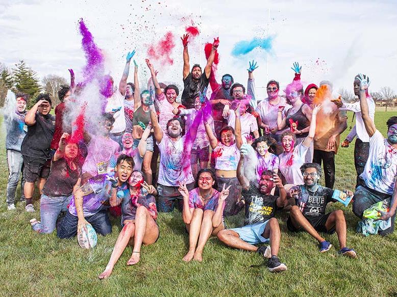 Students celebrate spring by throwing colorful powder