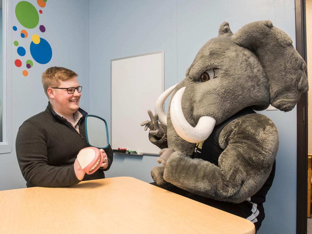 Don sits in a CSD lab with a student.