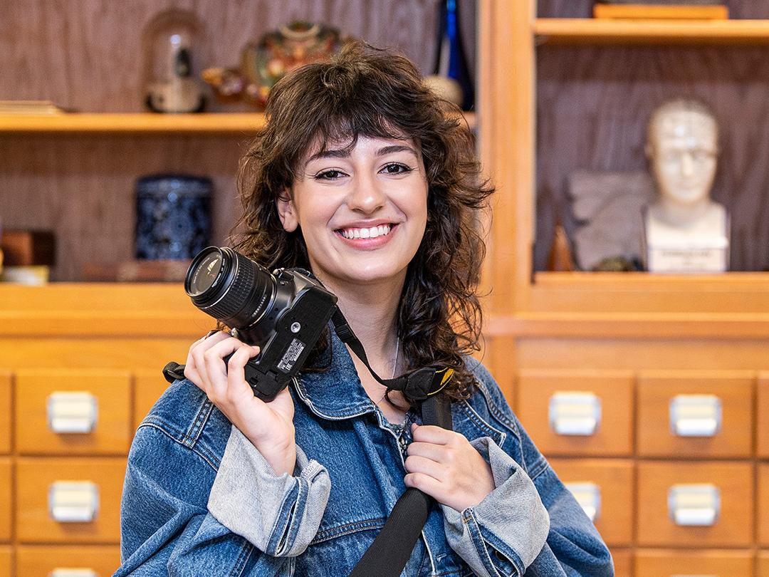 Bella Ferrin poses with her camera in the anthropology lab