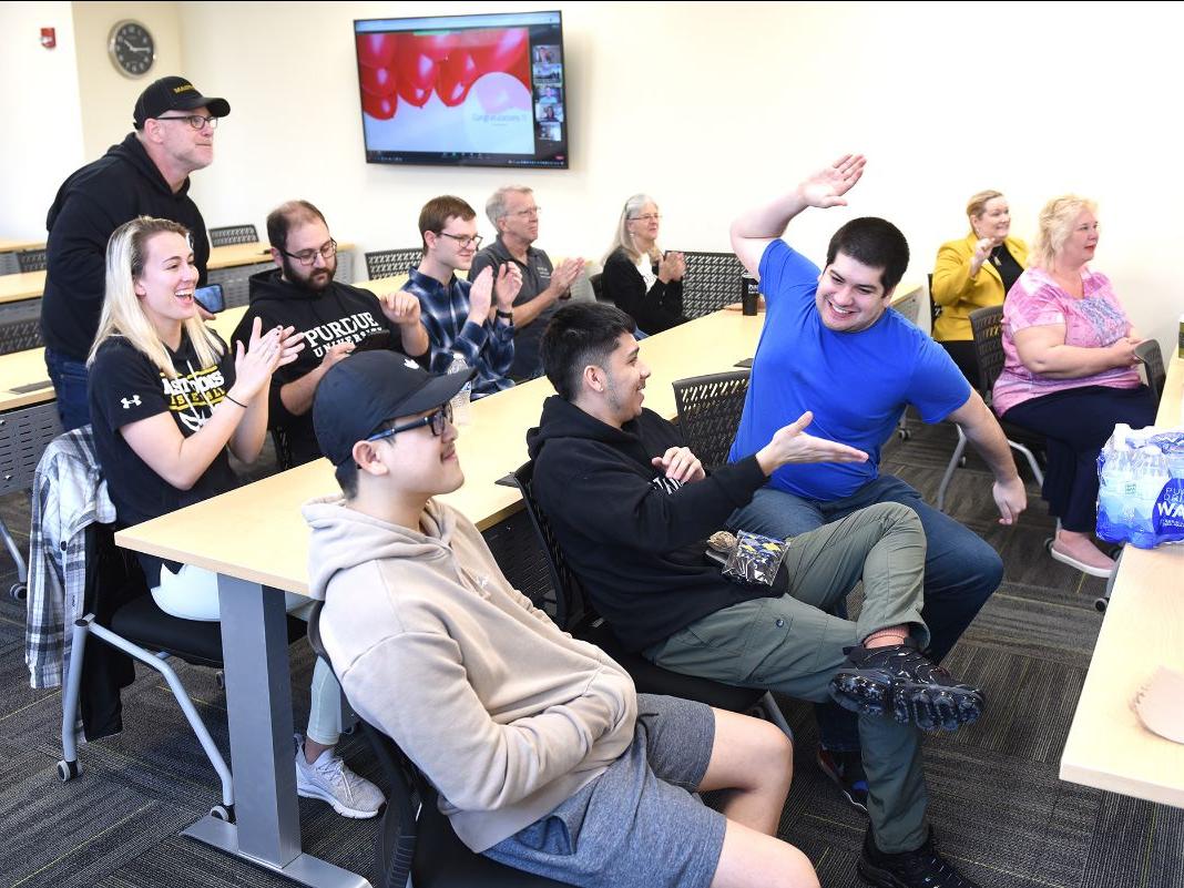 A gathering of students, faculty, and staff from the Doermer School of Business respond to positive news during the results webcast for the 2022 Flipping Finance Challenge