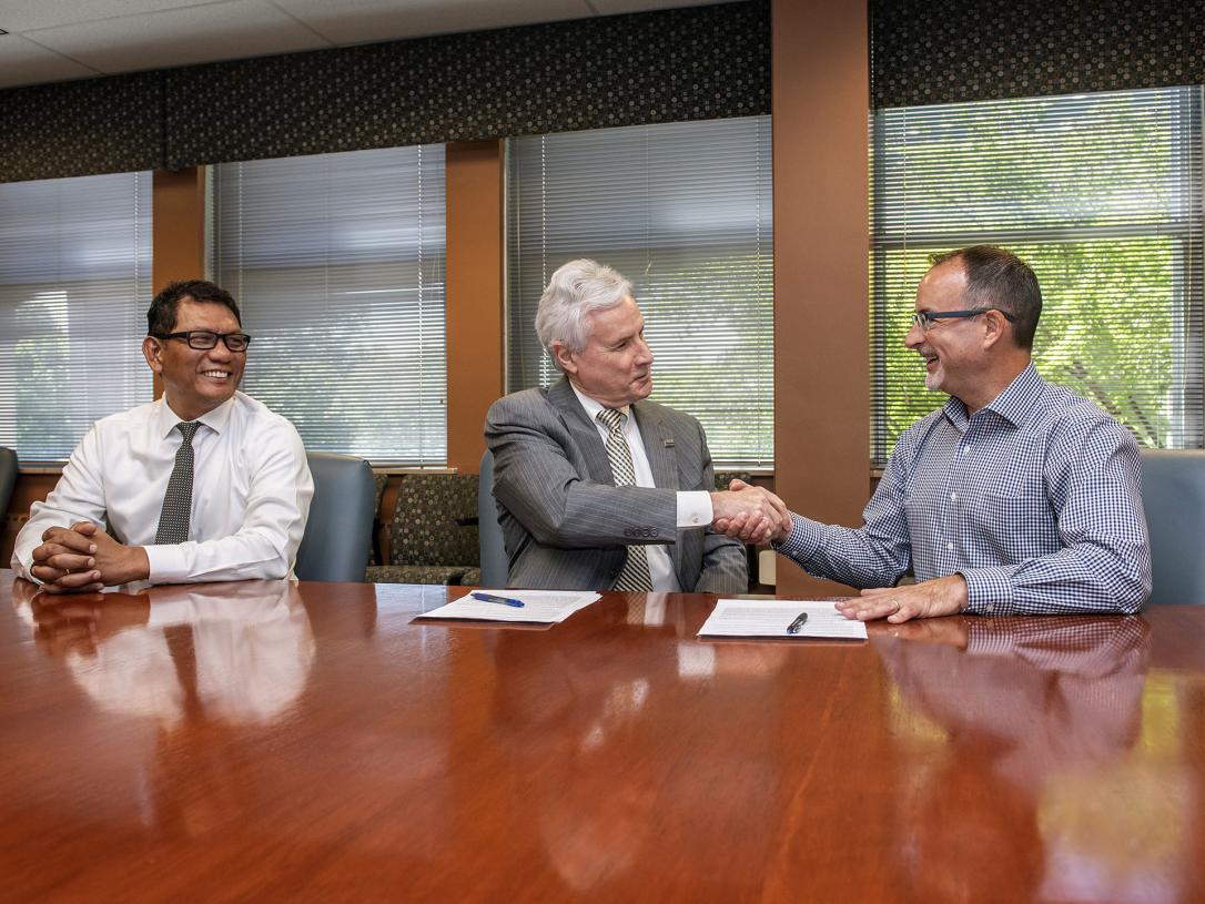 Chancellor Ron Elsenbaumer is flanked by Nyein Chan (left) and Dan Florin (right)