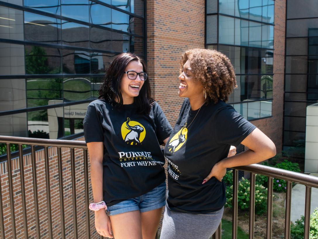 Two transfer students stand outside wearing PFW Transfer shirts.
