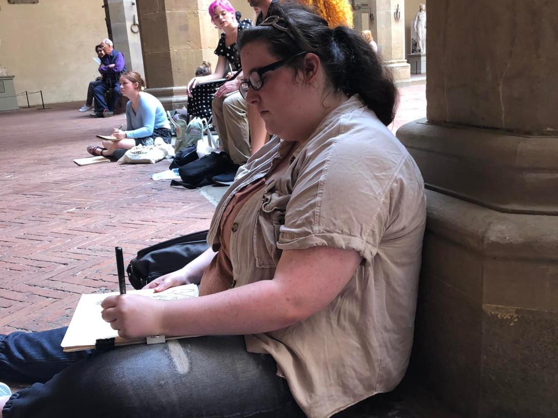 An art student is drawing outside
