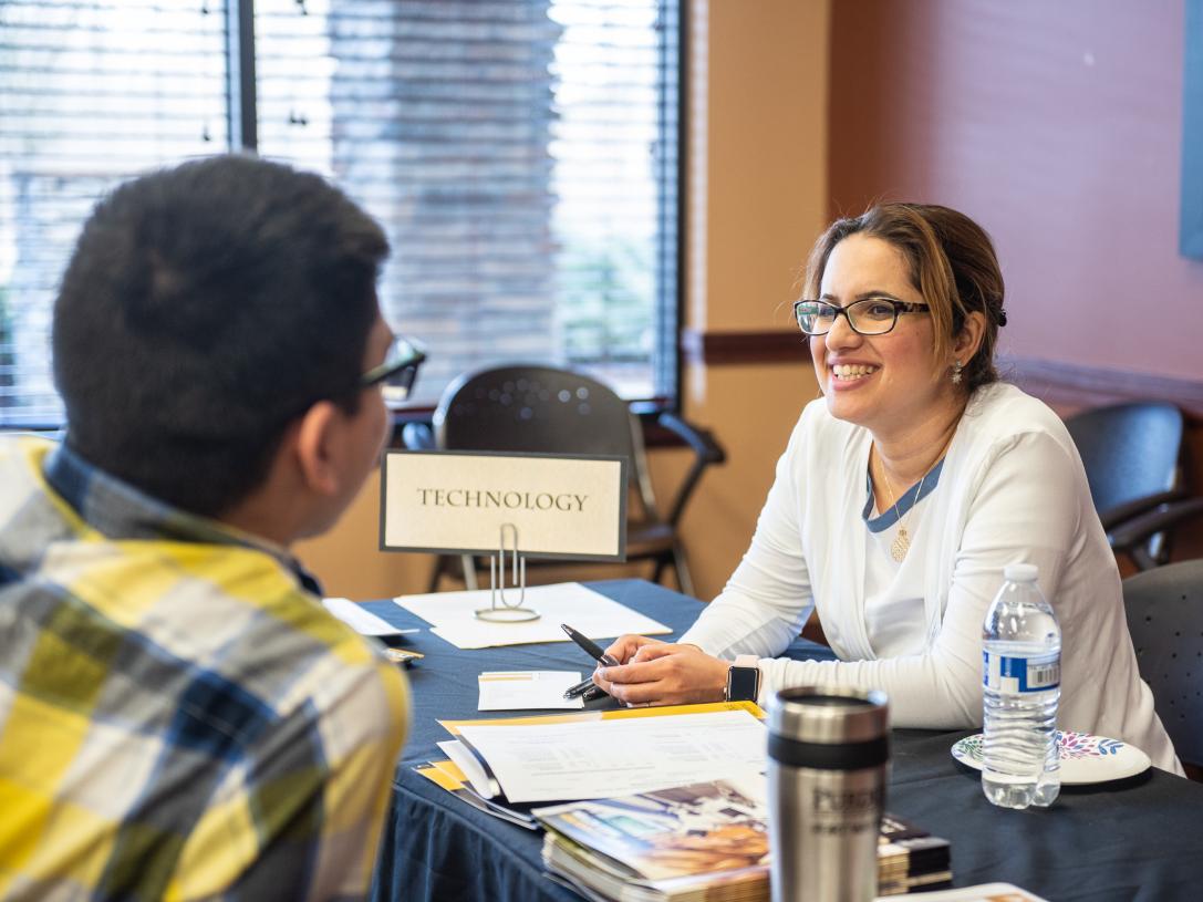 Behin Elahi chats with a potential student at a graduate studies open house
