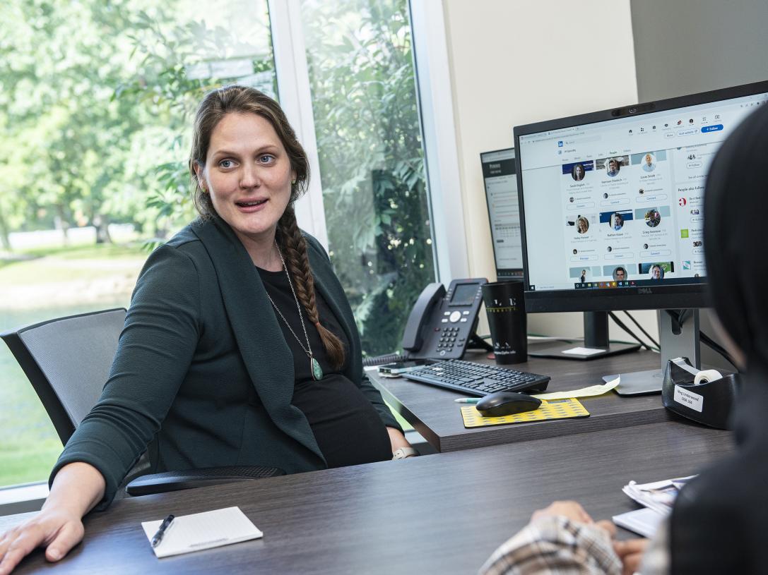 Meg Underwood meets with two students in her office.
