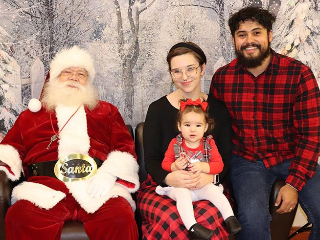 A family visits with Santa Claus at the Adopt-a-Don Jingle Jubilee dinner