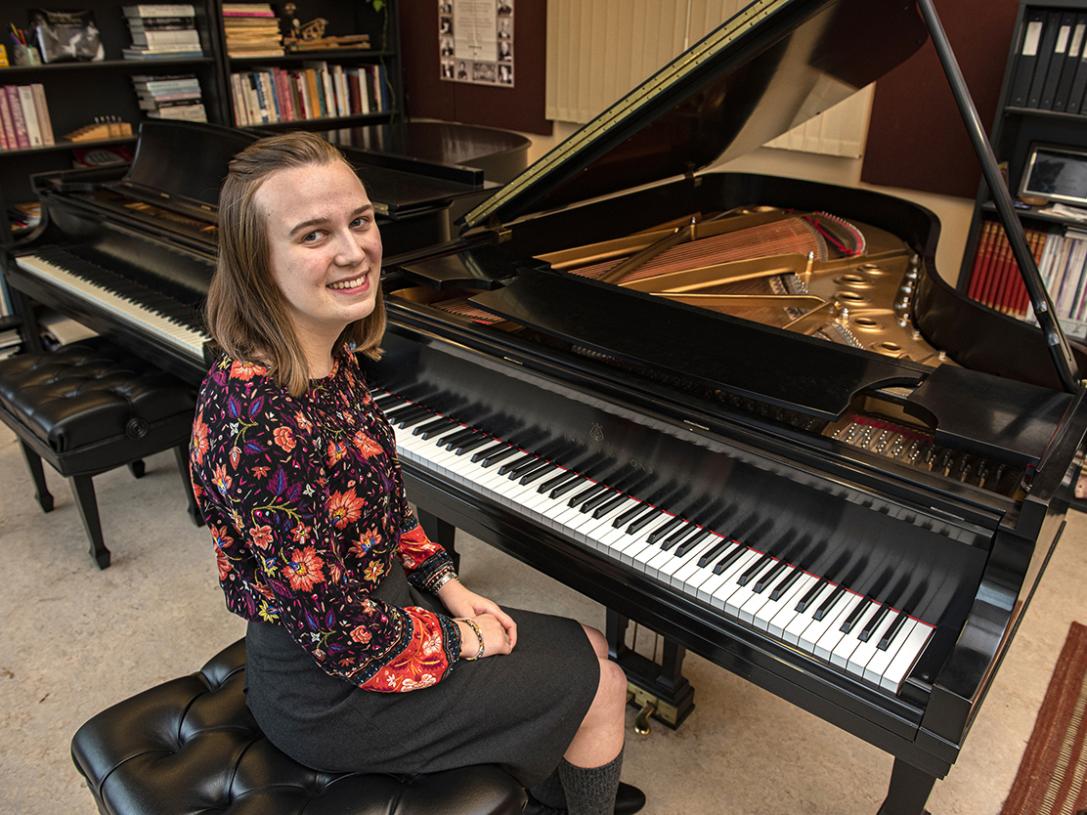 Cecilia Horner is smiling while seated at a piano