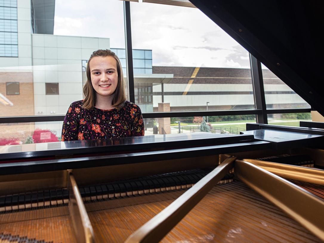 Cecilia Horner is smiling behind a grand piano