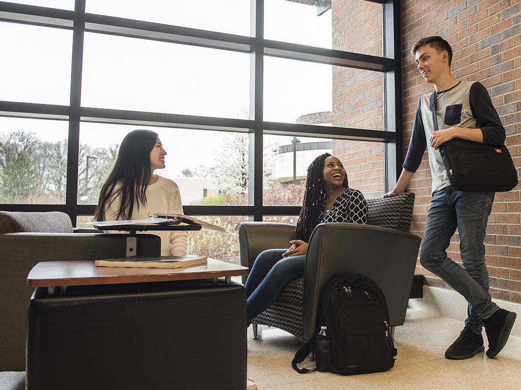 Three students are chatting in a hallway in Walb Student Union.