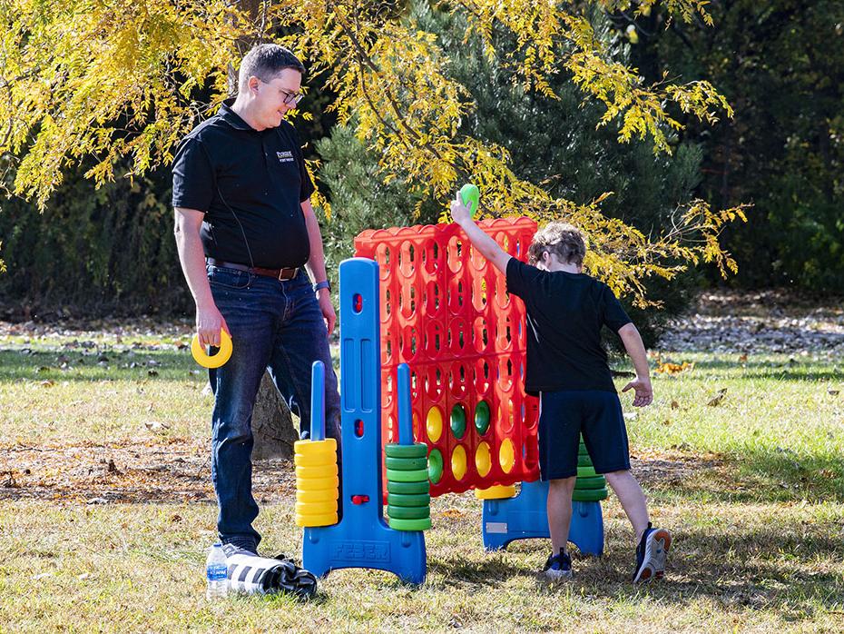 A parent his child play a game at the Mastodon Family Picnic